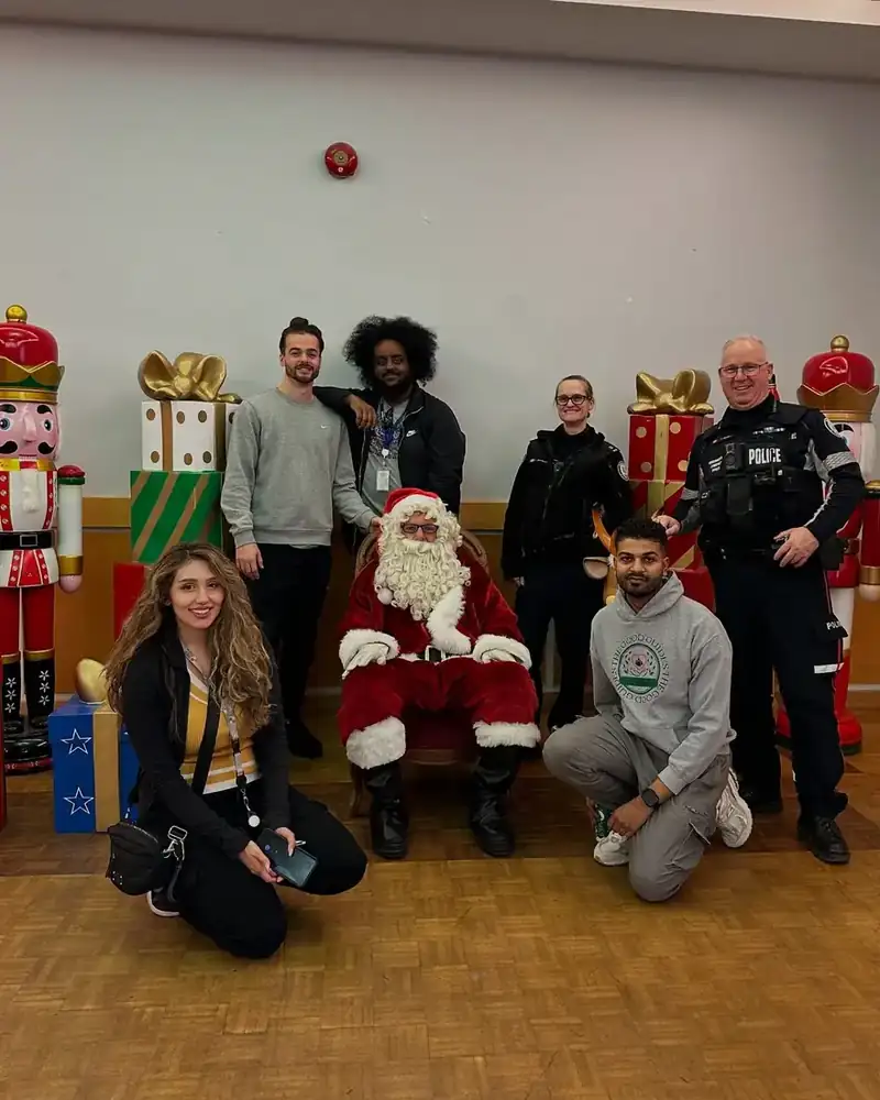 Good Guides team members and Toronto Police officers posing with Santa at Guided by Giving